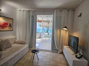 salon z kanapą i widokiem na ocean w obiekcie Beachfront House 13 ,Glyfada w mieście Glifada