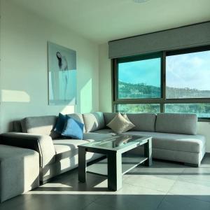 a living room with a couch and a coffee table at Le Six Hotel And Resort in Batro&ucirc;n