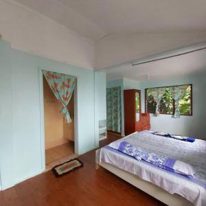 a bedroom with a large bed and two windows at Ocean White House in Savusavu