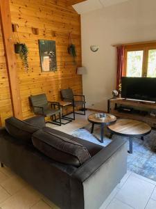 a living room with a couch and a piano at Vakantiehuis midden in het bos vlakbij de Efteling Natuurhuisje Loonse en Drunense duinen in Helvoirt