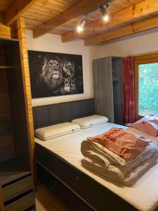 a bed in a room with a lion picture on the wall at Vakantiehuis midden in het bos vlakbij de Efteling Natuurhuisje Loonse en Drunense duinen in Helvoirt +14 photos
