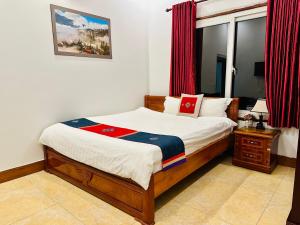 a bedroom with a bed and a window with red curtains at Thanh Quyen hotel in Sapa