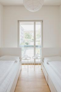 UzwilにあるServiced Apartments Haus 1の白いベッドルーム(ベッド2台、窓付)