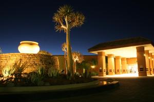 un edificio con una palmera delante de él en Desert Palace Hotel, en Upington