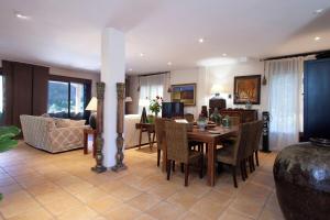 a dining room and living room with a table and chairs at Finca la Noguera-Sierra Cazorla in Quesada