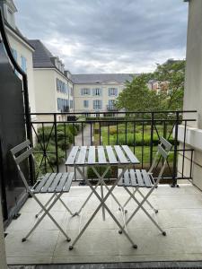 a picnic table and two chairs on a balcony at Spacious Marie apt in Serris