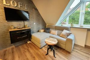 salon z kanapą i telewizorem z płaskim ekranem w obiekcie Nieman‘s Loft w mieście Emden