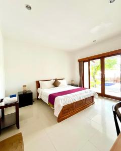 a bedroom with a large bed and a large window at Pererenan nengah guest house in Canggu