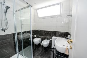 a bathroom with a glass shower and a sink at SWEET HOME DELUXe in Rosolini