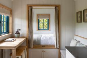 a bedroom with a mirror with a bed in it at Woodlands Shepherds HutChatsworth Estate in Baslow +3 photos