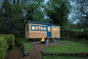 a tiny house with a fire in a yard at Stag Shepherds HutChatsworth Estate in Baslow
