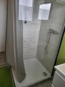 a shower with a glass door in a bathroom at Lajufe in Cormeilles