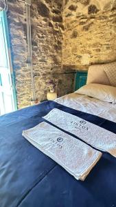 a blue bed with two towels on top of it at Fintoz Butika in Karaburun