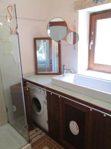 a bathroom with a sink and a washing machine at Case Vacanza La Vita A Cono in Cisternino