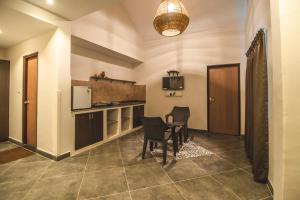 a kitchen with a table and chairs in a room at Amber Rooms in Porvorim
