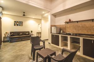 a kitchen with chairs and a couch in a room at Amber Rooms in Porvorim
