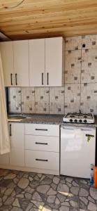a kitchen with white cabinets and a stove at Silahcılar apart pansiyon in Kumluca