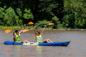 two women in a kayak on a lake at The Campster Kanchanaburi in Kanchanaburi City