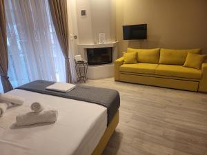 a bedroom with a bed and a yellow couch at Platanakia Houses in Ioannina