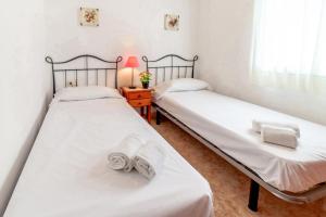 - 2 lits jumeaux dans une chambre avec une lampe et une table dans l'établissement Fener de Dalt 88 - apartamento con wifi y piscina, à Llançà 9 autres photos