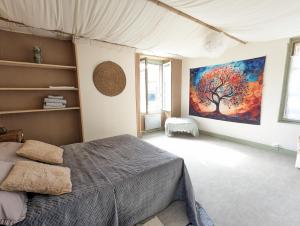 a bedroom with a tree painting on the wall at Vivez dans un magnifique village Normand in La Carneille