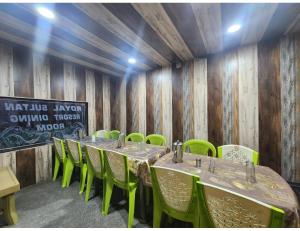 a room with tables and green chairs and a chalkboard at Hotel Royal sultan Resort, Pahalgam in Pahalgām