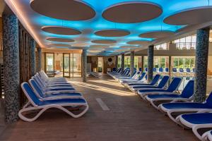 eine Reihe von Stühlen in einem Zimmer mit blauen Decken in der Unterkunft Hotel Karos Spa in Zalakaros