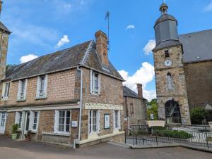an old brick building with a clock tower at Vivez dans un magnifique village Normand gîte de la Halle in La Carneille