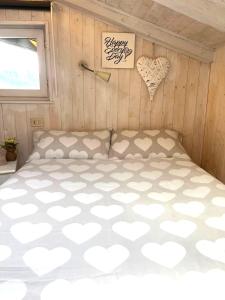 un letto in una stanza con cuori appesi al muro di Il piccolo Loft nel cuore antico di Aosta - You & Me case vacanza ad Aosta