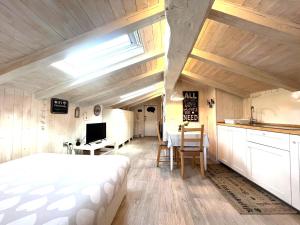 una camera con letto e una cucina con tavolo di Il piccolo Loft nel cuore antico di Aosta - You & Me case vacanza ad Aosta