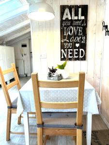 un tavolo con due sedie e un cartello sul muro di Il piccolo Loft nel cuore antico di Aosta - You & Me case vacanza ad Aosta