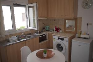 a kitchen with a sink and a washing machine at Sufiko Studios - Thea in Armenistis