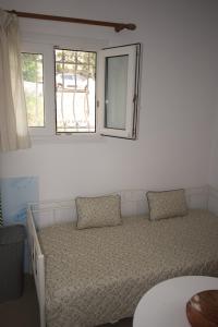 a bedroom with a bed and a mirror on the wall at Sufiko Studios - Thea in Armenistis