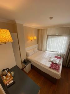 um quarto de hotel com uma cama e uma mesa em Eterno Hotel em Istambul