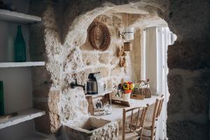 a kitchen with a stone wall with a table and chairs at Dei Serafini in Polignano a Mare +37 photos