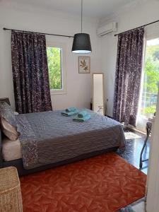 a bedroom with a bed and a large window at Serene Country House (near Ancient Tiryns) in Nafplio