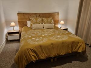 a bedroom with a large bed with two lamps at Le Gîte du Cerisier in Gy-les-Nonains
