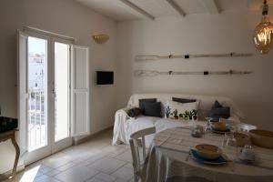 a white living room with a bed and a table at Dei Serafini in Polignano a Mare