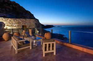 a balcony with a view of the ocean at night at Stone Luxury Suites - Adults Only in Archangelos