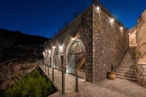 a stone building with stairs and lights on it at Stone Luxury Suites - Adults Only in Archangelos