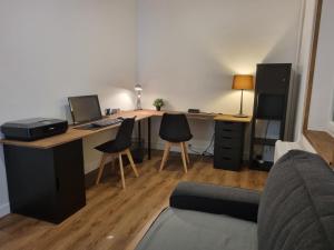 an office with a desk with a computer and two chairs at Le Gîte du Cerisier in Gy-les-Nonains +8 photos