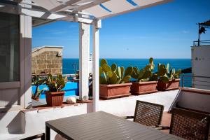 a patio with cactuses and a table and chairs at Dei Serafini in Polignano a Mare