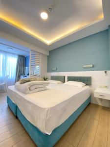 a large bed in a bedroom with blue walls at Amsterdam Otel & Suite Apart in Kemer