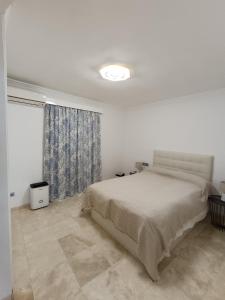 a white bedroom with a bed and a window at Carabeo 36 Duplex in Nerja +17 photos