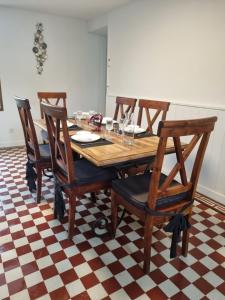 a dining room table with four wooden chairs at Le Gîte du Cerisier in Gy-les-Nonains