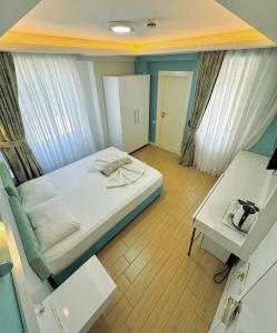 Habitación pequeña con cama y escritorio. en Amsterdam Otel & Suite Apart en Kemer