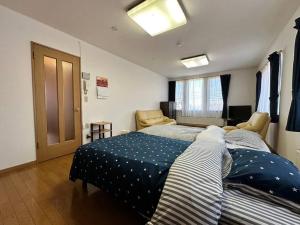 a bedroom with a bed with a blue comforter at Shakotan Detached House Stay in Shakotan