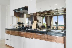 a kitchen with white cabinets and a sink at Bhumi by Kozystay - Paskal in Bandung