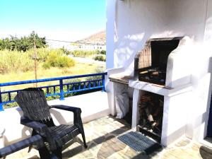 a patio with a fireplace and a chair on a balcony at Angelina Greek House in Parikia