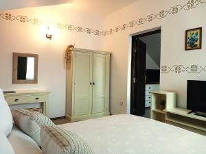 a bedroom with a bed and a television at Casa Calin in Vama